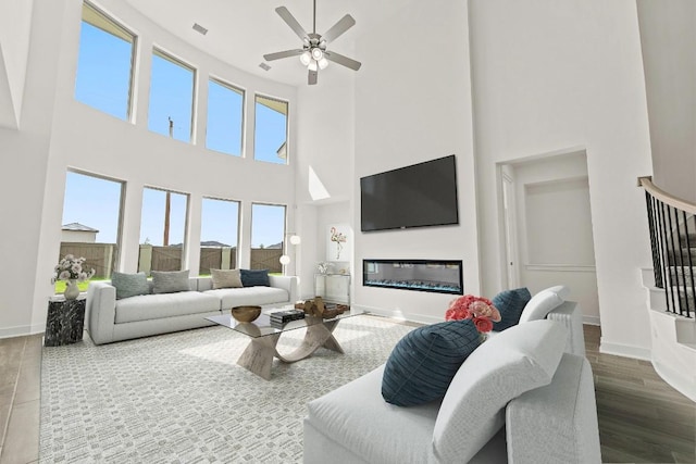 7413 Desert Needle Dr, Lago Vista, TX 78645 - living area with a towering ceiling, baseboards, ceiling fan, wood finished floors, and a glass covered fireplace