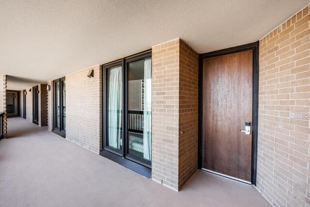 entrance to property featuring brick siding