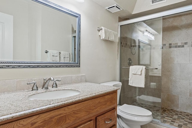 bathroom featuring vanity, visible vents, a shower stall, and toilet