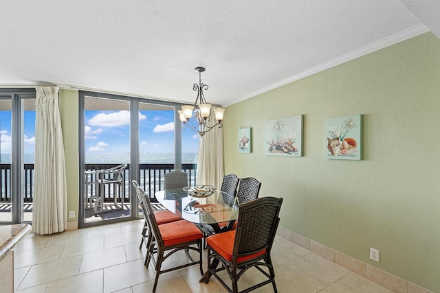 dining room featuring a textured ceiling, a water view, an inviting chandelier, expansive windows, and ornamental molding
