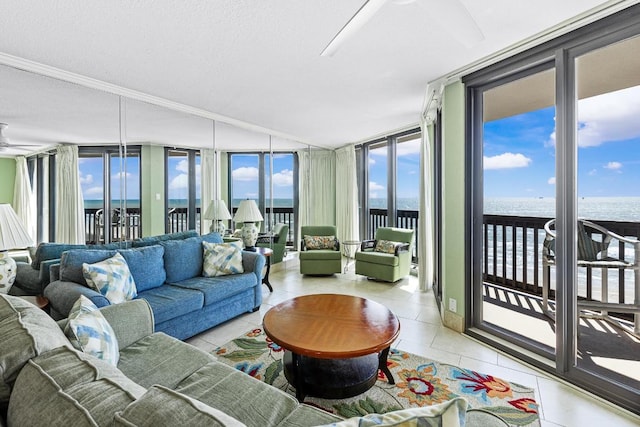 living area featuring expansive windows, a water view, ceiling fan, and light tile patterned floors