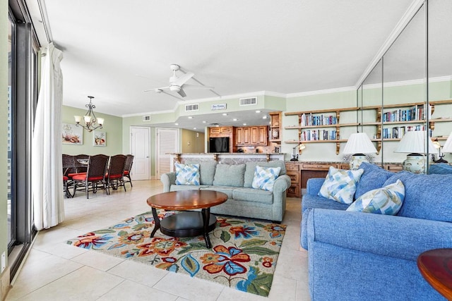 living room with light tile patterned flooring, ceiling fan with notable chandelier, visible vents, and crown molding