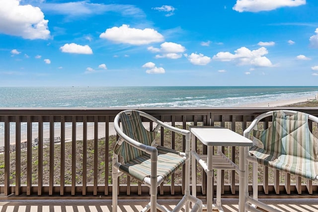 balcony featuring a beach view and a water view