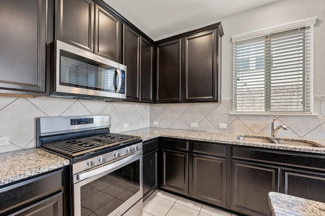 7001 Midlothian Dr, Austin, TX 78754 - kitchen featuring appliances with stainless steel finishes, a sink, light stone counters, and tasteful backsplash