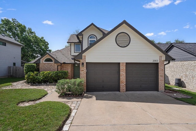 2003 Ploverville Ln, Austin, TX 78728 - traditional-style home with brick siding, central air condition unit, an attached garage, and concrete driveway