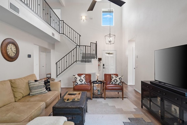 2003 Ploverville Ln, Austin, TX 78728 - living area with stairway, a towering ceiling, light wood finished floors, baseboards, and visible vents
