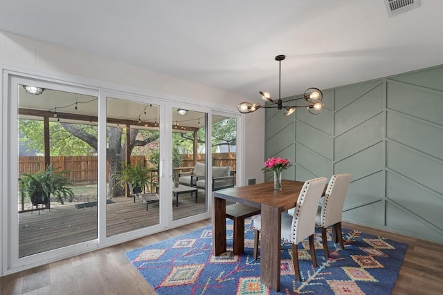 2003 Ploverville Ln, Austin, TX 78728 - dining area featuring wood finished floors, visible vents, a chandelier, and a decorative wall