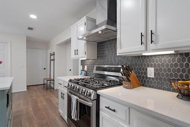 2003 Ploverville Ln, Austin, TX 78728 - kitchen with wood finished floors, stainless steel gas range, light countertops, wall chimney exhaust hood, and visible vents
