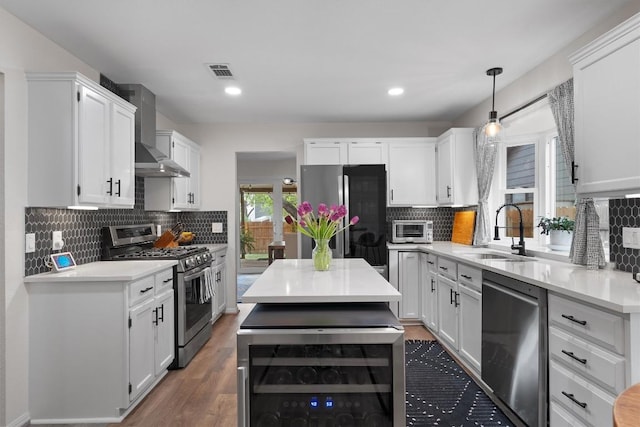 2003 Ploverville Ln, Austin, TX 78728 - kitchen featuring wall chimney range hood, a sink, stainless steel appliances, visible vents, and wine cooler