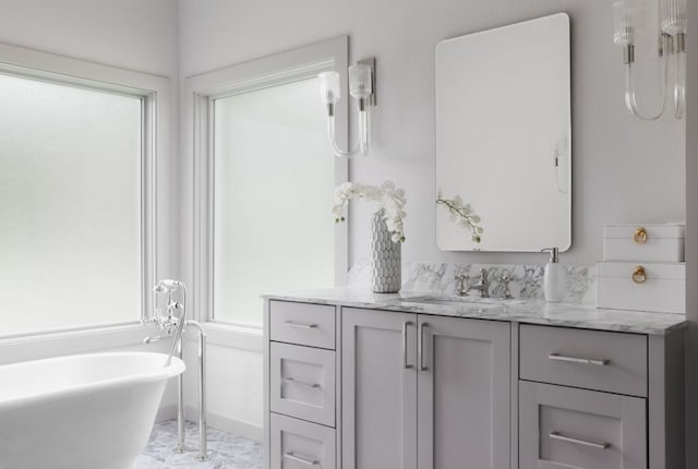 bathroom with vanity, a freestanding bath, and marble finish floor