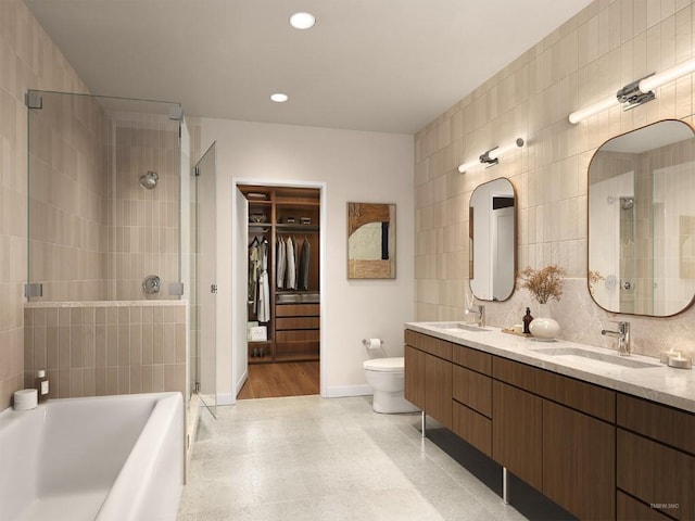 bathroom with tile walls, a garden tub, a shower stall, and a sink