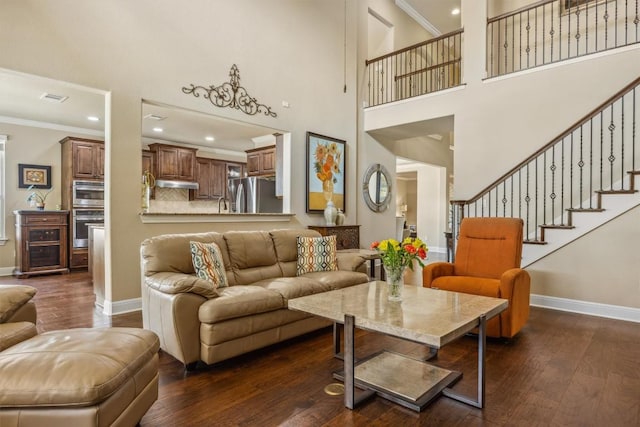 2505 Livenza Pl, Leander, TX 78641 - living area with dark wood-style floors, crown molding, recessed lighting, a high ceiling, and stairs