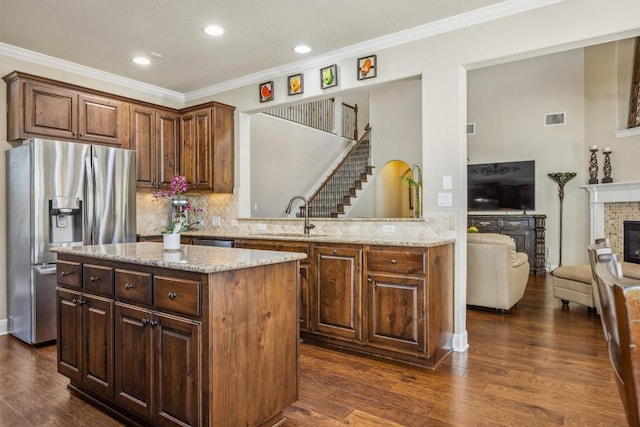 2505 Livenza Pl, Leander, TX 78641 - kitchen with stainless steel appliances, a center island, decorative backsplash, ornamental molding, and dark wood-type flooring