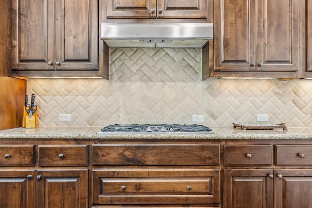 2505 Livenza Pl, Leander, TX 78641 - kitchen featuring stainless steel gas stovetop, range hood, tasteful backsplash, and light stone counters
