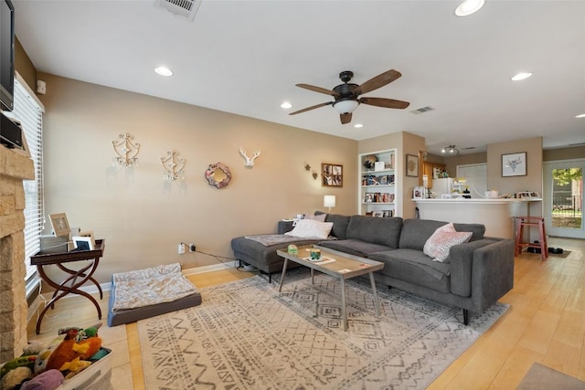 living area with visible vents, a stone fireplace, recessed lighting, and ceiling fan