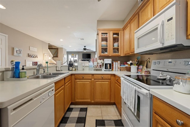 kitchen featuring light countertops, ceiling fan, a sink, and white appliances