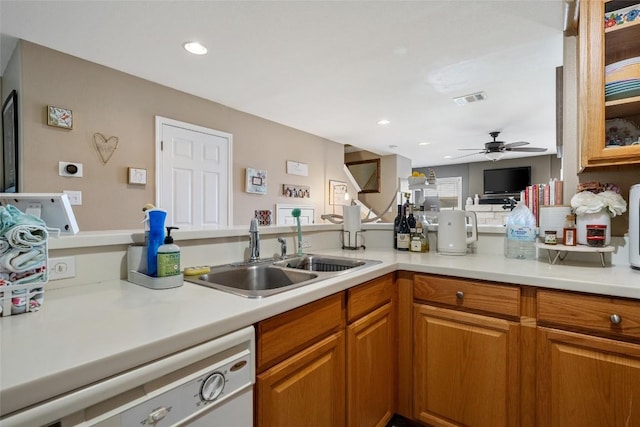 kitchen with white dishwasher, a sink, ceiling fan, light countertops, and visible vents