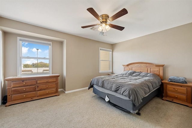 bedroom featuring ceiling fan, light carpet, visible vents, and baseboards