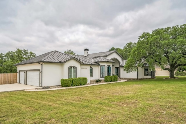single story home with a standing seam roof, driveway, fence, metal roof, and an attached garage