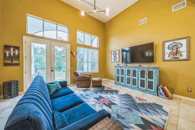 tiled living area featuring baseboards, french doors, visible vents, and high vaulted ceiling