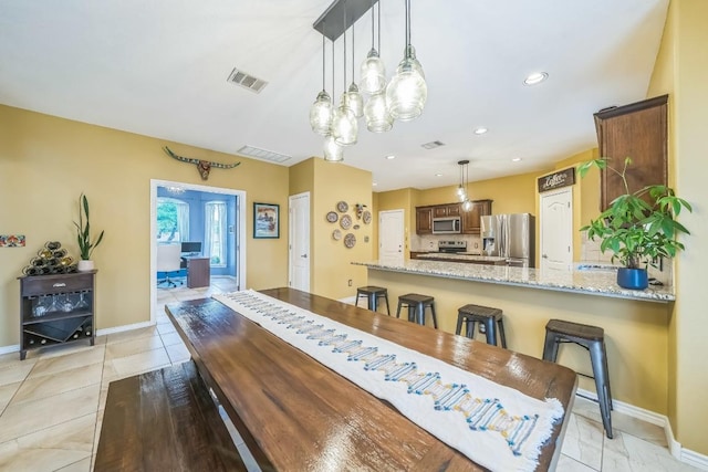 dining area with baseboards, a notable chandelier, visible vents, and light tile patterned floors
