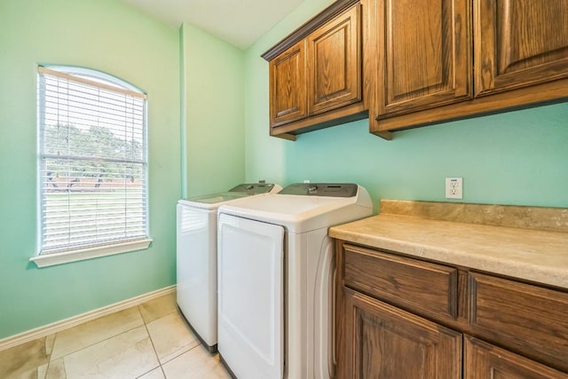 laundry area with cabinet space, baseboards, and washer and clothes dryer