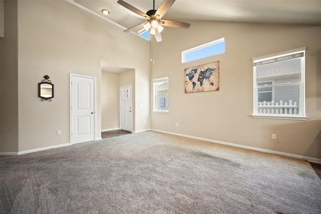 carpeted empty room featuring high vaulted ceiling, baseboards, and a ceiling fan