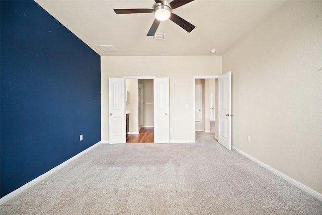unfurnished bedroom with carpet, visible vents, baseboards, and ceiling fan