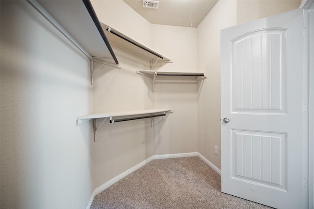 spacious closet featuring visible vents and carpet