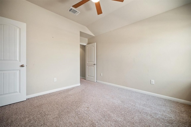 carpeted spare room with lofted ceiling, visible vents, baseboards, and ceiling fan
