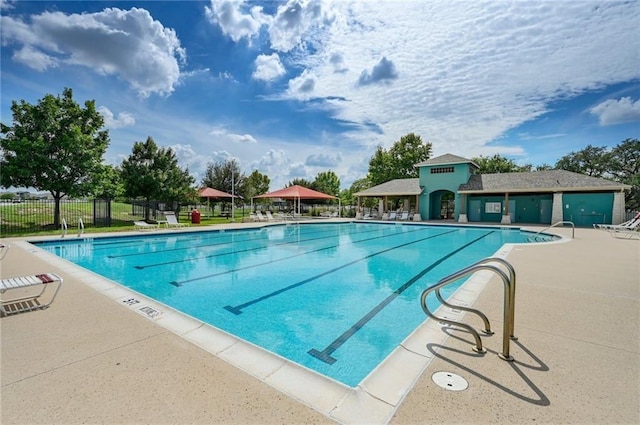 community pool with fence and a patio