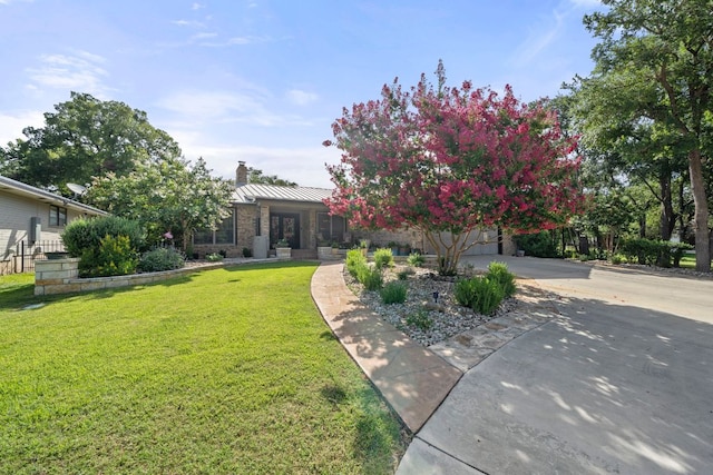 25 Doolittle Dr, Wimberley, TX 78676 - view of front of house with a chimney, a front lawn, a standing seam roof, driveway, and stone siding
