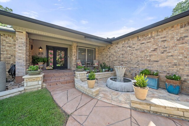 property entrance with brick siding and a porch