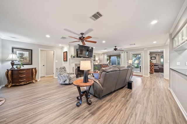 25 Doolittle Dr, Wimberley, TX 78676 - living area featuring a large fireplace, ornamental molding, light wood-style floors, ceiling fan, and baseboards