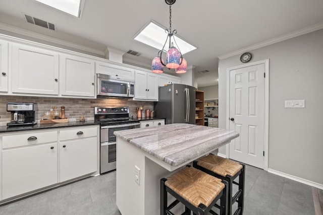 kitchen featuring crown molding, visible vents, appliances with stainless steel finishes, and decorative backsplash