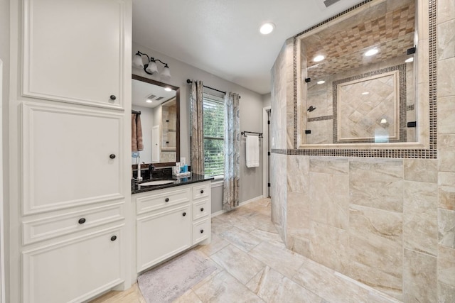25 Doolittle Dr, Wimberley, TX 78676 - full bath with tiled shower, vanity, marble finish flooring, recessed lighting, and baseboards