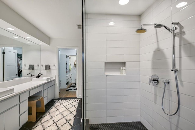 1213 Falcon Ledge Dr, Austin, TX 78746 - bathroom with tiled shower, double vanity, recessed lighting, a spacious closet, and tile patterned flooring