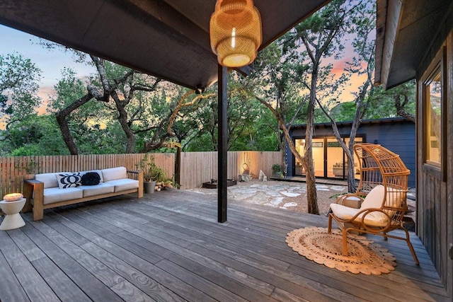 1213 Falcon Ledge Dr, Austin, TX 78746 - deck at dusk with a fenced backyard and an outdoor hangout area