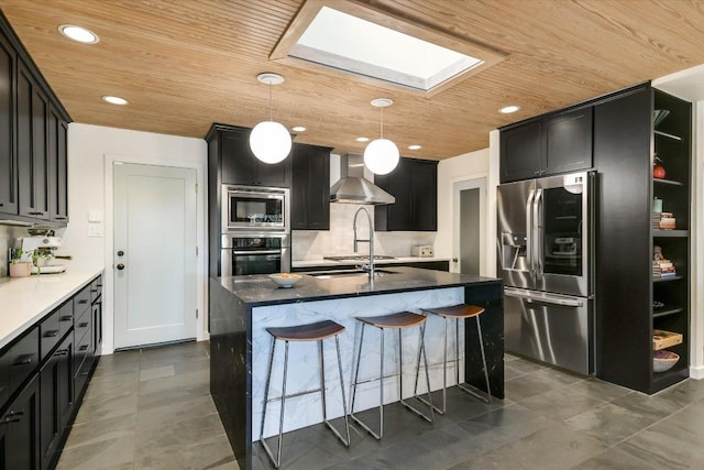 1213 Falcon Ledge Dr, Austin, TX 78746 - kitchen featuring stainless steel appliances, wooden ceiling, wall chimney range hood, a skylight, and a breakfast bar area