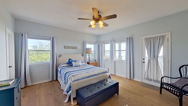 bedroom with light wood-type flooring, a ceiling fan, and baseboards