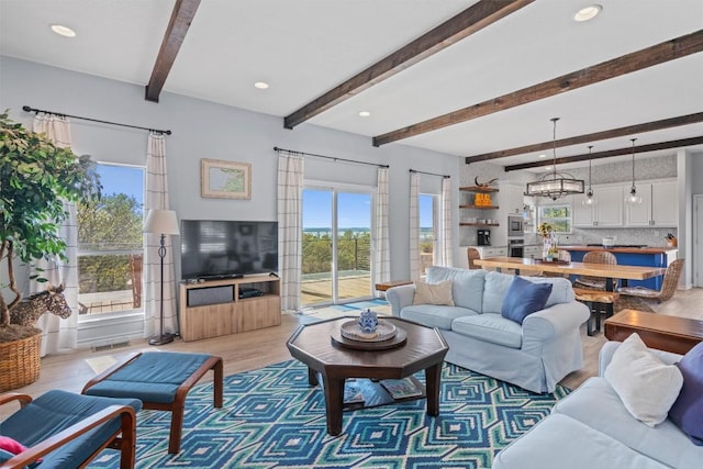 living area featuring a wealth of natural light, wood finished floors, beam ceiling, and recessed lighting