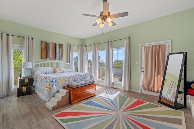 bedroom with wood finished floors, a ceiling fan, and access to outside