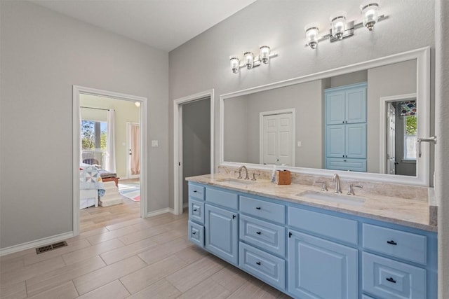 bathroom with baseboards, visible vents, a sink, and double vanity