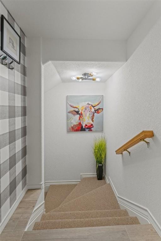 staircase with wood finished floors and baseboards