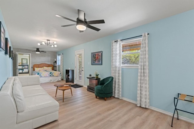 living area featuring ceiling fan, baseboards, and wood finished floors