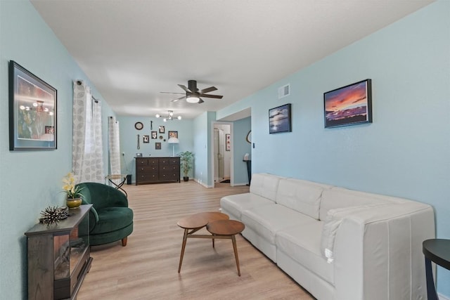 living room featuring a ceiling fan, visible vents, and light wood-style floors