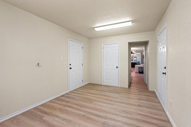 unfurnished room featuring baseboards and light wood-style floors