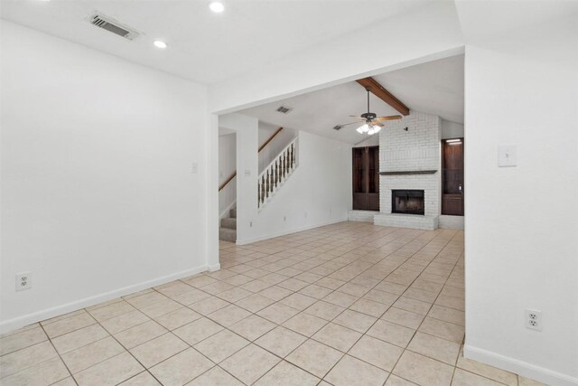 2210 Lasso Dr, Round Rock, TX 78681 - unfurnished living room featuring a fireplace, vaulted ceiling with beams, visible vents, and light tile patterned floors