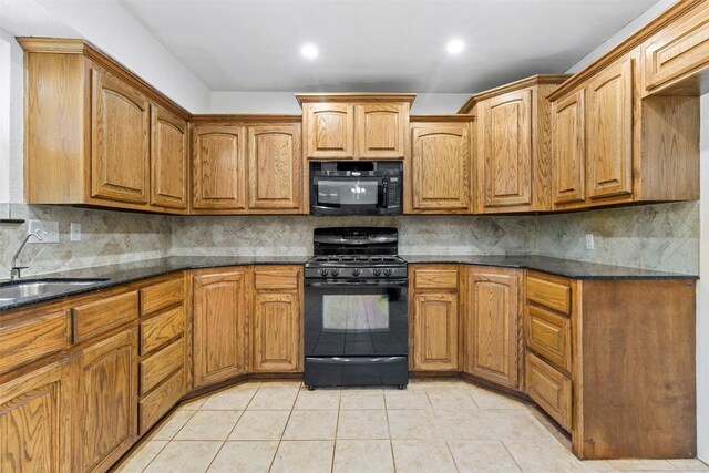 2210 Lasso Dr, Round Rock, TX 78681 - kitchen featuring brown cabinets, light tile patterned floors, a sink, and black appliances