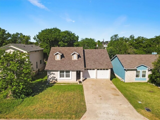 2210 Lasso Dr, Round Rock, TX 78681 - cape cod-style house with an attached garage, a shingled roof, a front yard, and concrete driveway